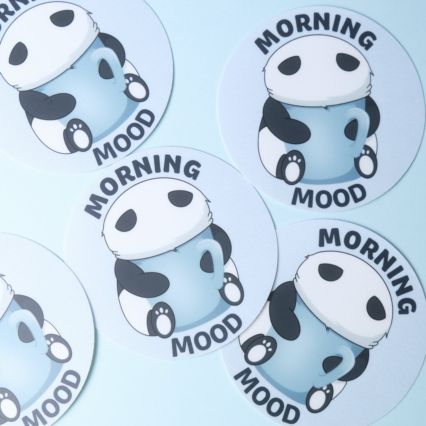 Round sticker of our cute panda with his face in a large mug with the phrase “Morning Mood”