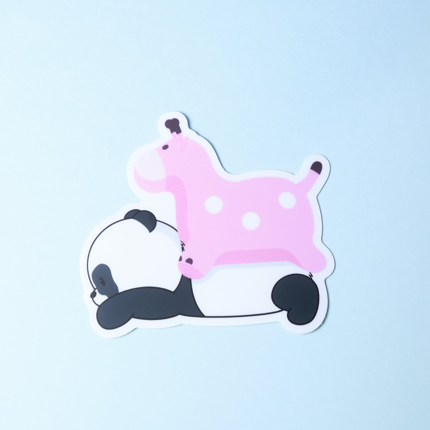 Die-cut sticker of our cute panda lying down with a pink blow up giraffe on his back