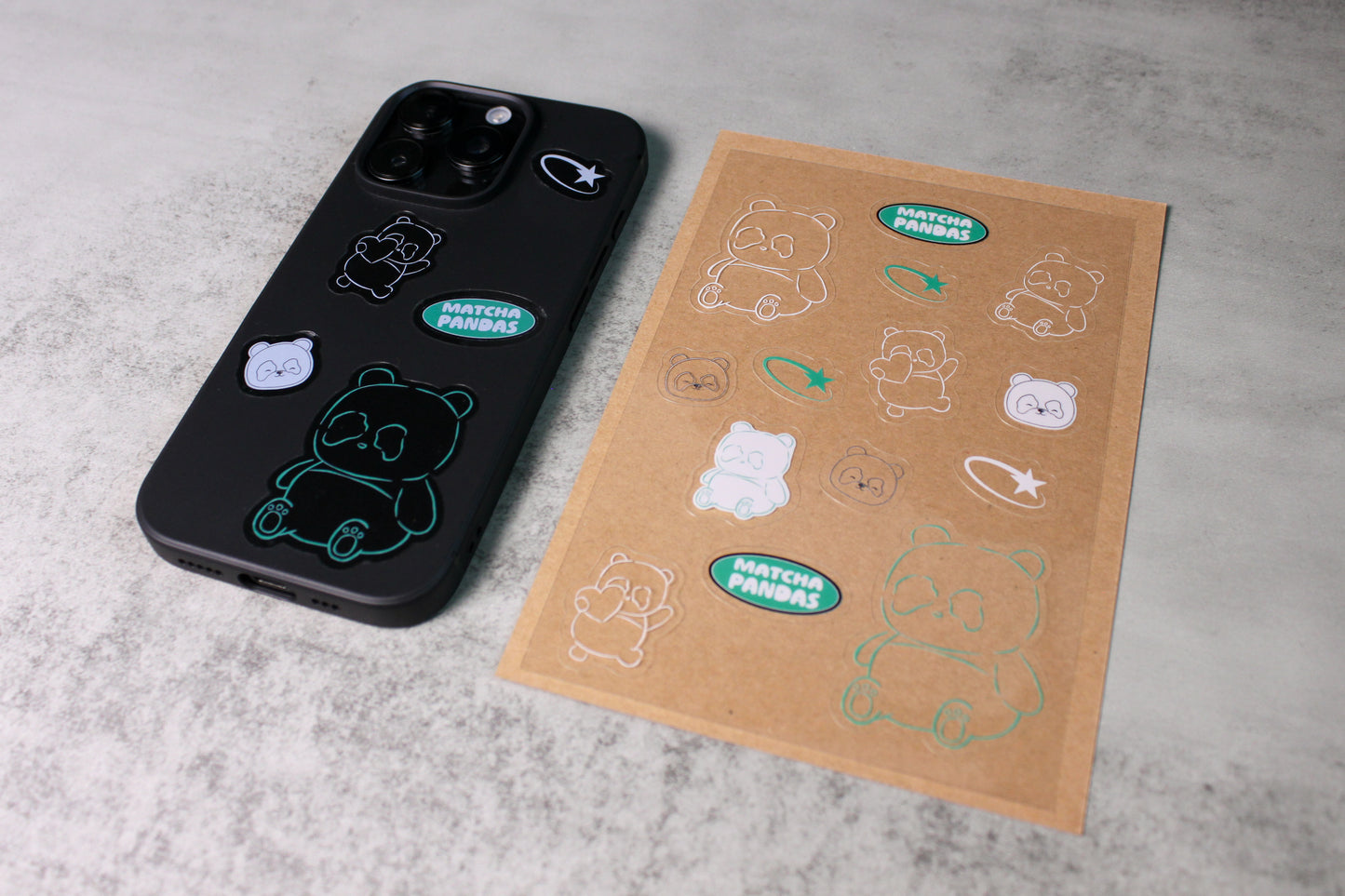 Phone case with the Scribble stickers and a sheet of the Scribble Stickers on a gray surface