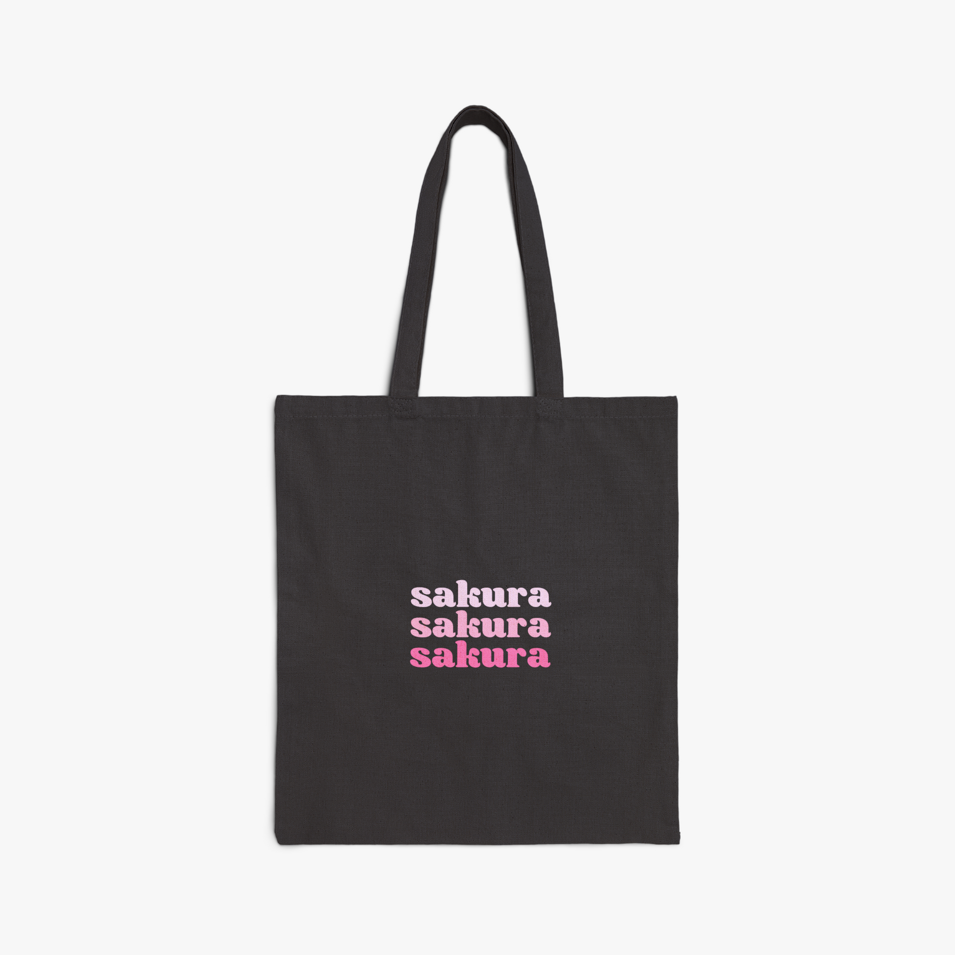 Black tote bag with "sakura" repeated text in pink gradient