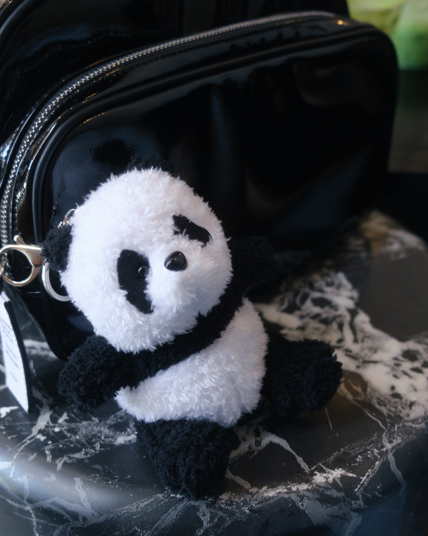 Soft black and white panda plush keychain with a cute embroidered face and fluffy fabric attached to a metal keyring.