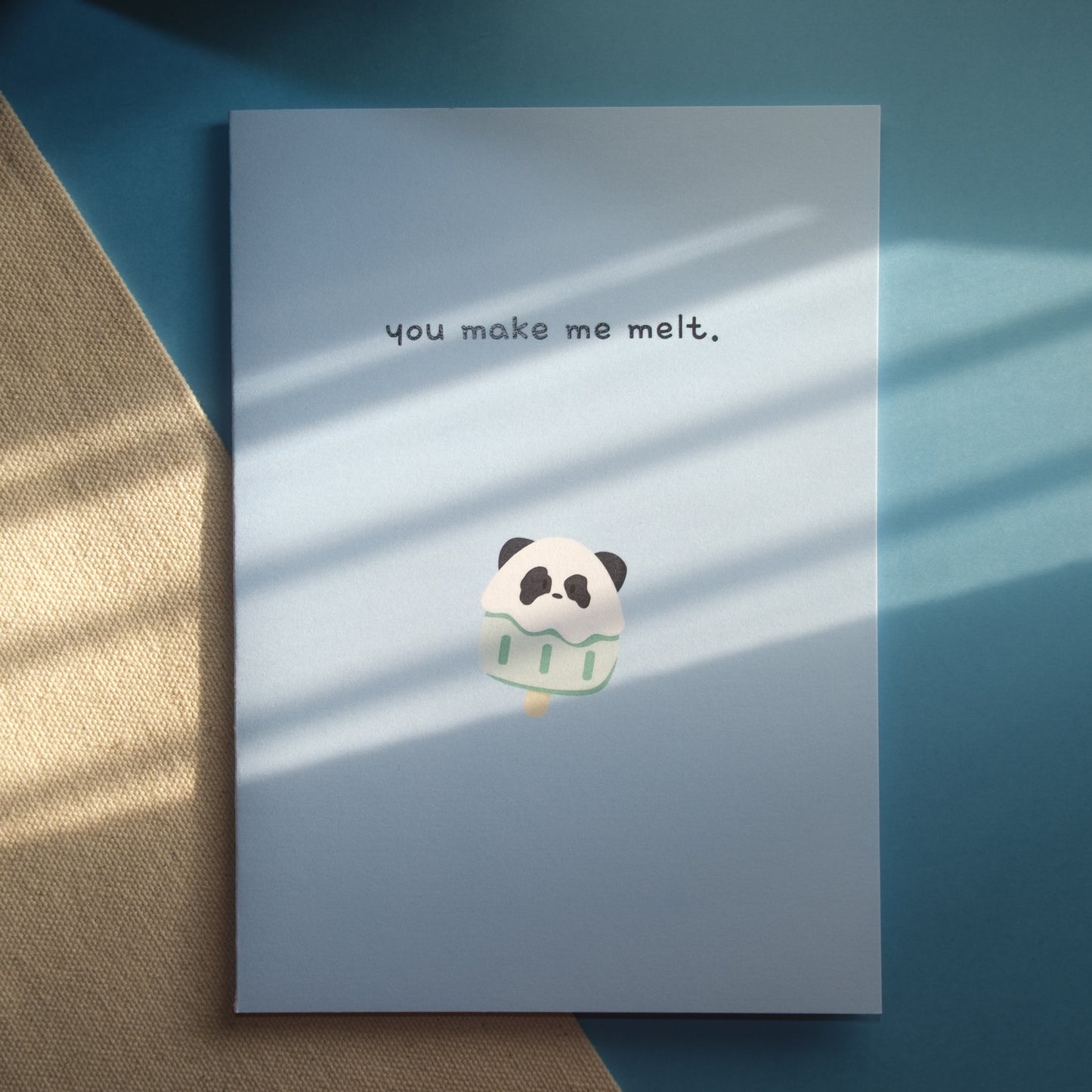 Light blue greeting card with a panda popsicle and the text, "you make me melt."