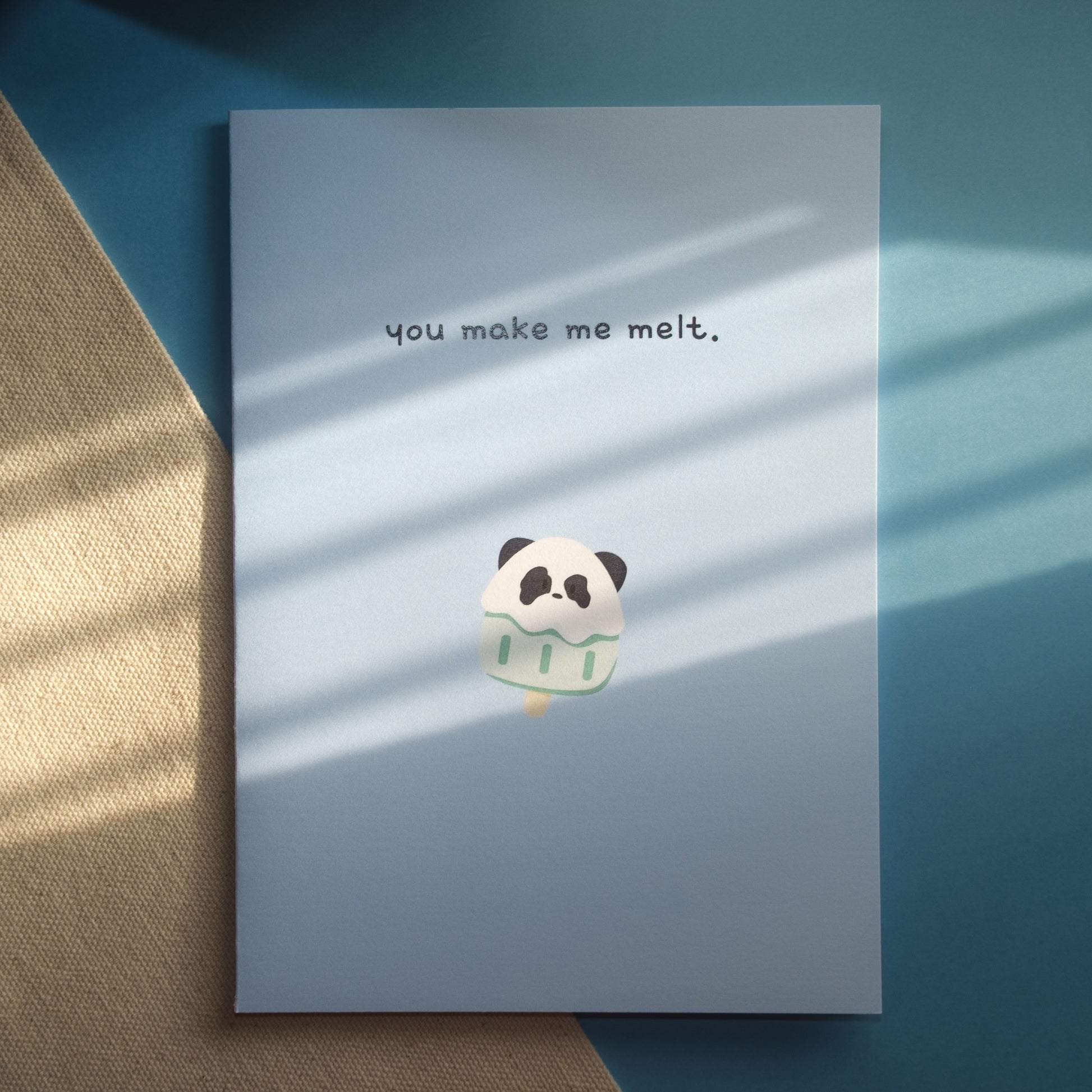Light blue greeting card with a panda popsicle and the text, "you make me melt."
