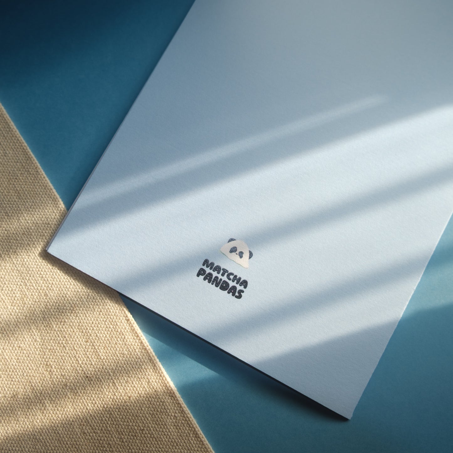 Back of card - light blue card, Matcha Pandas logo, and melting panda popsicle